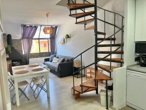 a living room with a spiral staircase and a table at DUPLEX EN LA NIEVE in La Molina