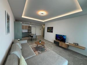 a living room with a couch and a tv at Dioneida Apartments in Sarandë