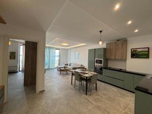 a kitchen and living room with a table and chairs at Dioneida Apartments in Sarandë