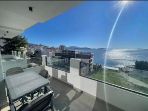 a balcony with a table and a view of the water at Dioneida Apartments in Sarandë