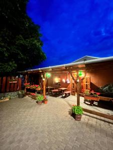 a patio of a house with plants and lights at London Hostel in Dabas