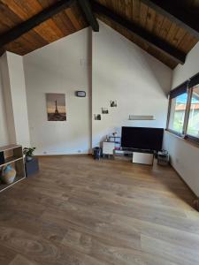 a large living room with wooden floors and a flat screen tv at Casetta Friulana in Udine