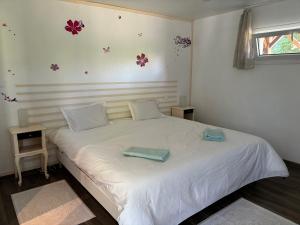 NernierLa villa Émeraude的卧室里有一张白色的床，床上有两条毛巾
