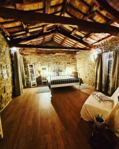 una grande camera con un letto e un muro in pietra di Casa Villanova ROMANCE a Sečovlje