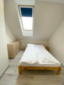 a small bedroom with a bed with a window at Double House MAGI in Kowary