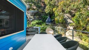 a table and chairs on the balcony of a house at 'Putty Beach Retreat' by HolidayCo in Killcare