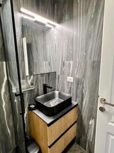 a black bathroom with a sink and a mirror at Casa Ilinca in Dărmăneşti +59 photos