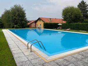 a large blue swimming pool in a yard at Appartamento al lago in Corgeno