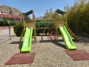 a playground with green slides in a park at La casa di Giada in Calatabiano