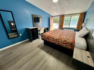 a hotel room with a bed and a desk at Knights Inn Greenville in Greenville