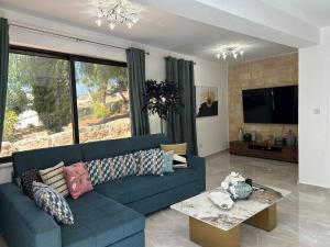 a living room with a blue couch and a table at Luxury Kouklia Maisonette in Paphos