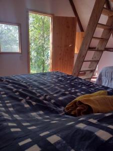 ヒリトゥラにあるCabaña Calandriaの青い掛け布団が敷かれたベッドのある寝室