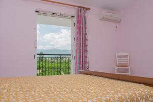 a bedroom with a bed and a large window at ΑΚΤΗ ΞΟΒΡΙΟΣ in Kiveri