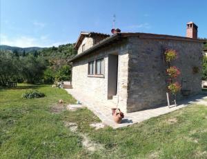 a small stone building with a grassy field next to it at Agriturismo I Cipressi in Pontassieve