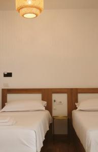 a bedroom with two beds and a chandelier at NOIMA Hotel & Suites in Velipojë +33 photos