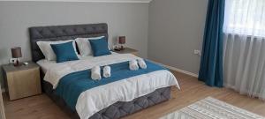a bedroom with a large bed with blue pillows at Villa 'Whispering Pines' Ilidža in Sarajevo +36 photos