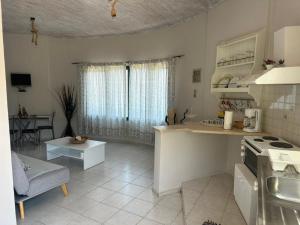 una cucina e un soggiorno con piano cottura e tavolo di Razos Windmill a Vathi Altre 17 foto
