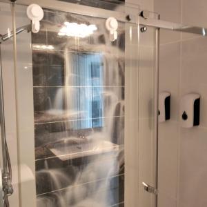 a shower with a glass door with a sink at Wind House in Costa de Antigua
