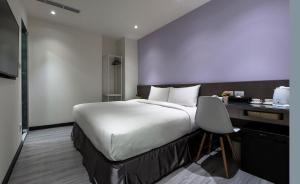 Una habitación de hotel con una cama grande y un escritorio. en Mitsu ko shi mae 101-4, en Taipéi