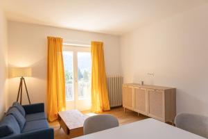 a living room with a blue couch and a window at Top Four See- & Bergblickapartment - 250m vom Seeufer in Döbriach
