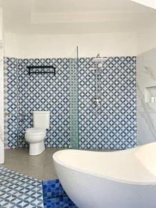 Un baño con bañera y WC. en Honeymoon Private Pool Villa - Fulton Avalon, en Ngaglik 11 fotos más