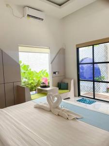 Una habitación con una cama con dos cisnes. en Honeymoon Private Pool Villa - Fulton Avalon, en Ngaglik