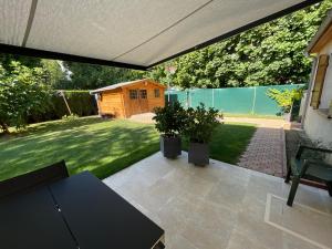 a patio with two potted plants and a house at Chambre climatisée, entre Paris Disneyland, au coeur des Jeux Olympiques canoë-kayak, in Vaires-sur-Marne +8 photos
