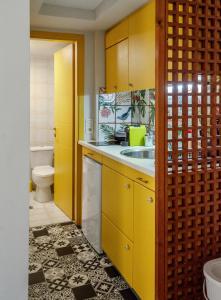een gele keuken met een wastafel en een toilet bij Little Summer House in Toploú