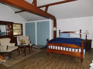 een slaapkamer met een bed, een bank en een stoel bij Country living at the Barn in Chiefland