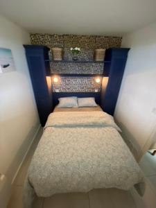 - une petite chambre avec un lit doté d'une tête de lit bleue dans l'établissement Charmant appartement en front de mer avec piscine, à Lacanau-Océan