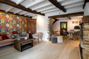 a living room with a couch and a table at La petite maison du Gastronome in Paliseul
