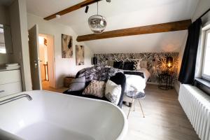 a bathroom with a bath tub and a bedroom at La petite maison du Gastronome in Paliseul