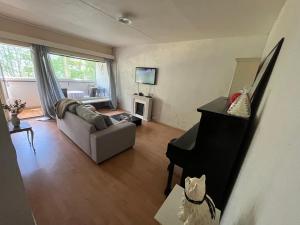 a living room with a couch and a piano at Spacious Two Room Apartment in Espoo in Espoo