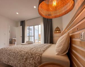 a bedroom with a large bed and a chandelier at UpTown Apartments in Horta
