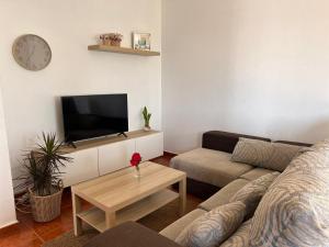 a living room with a couch and a tv at Mar en Calma in Teguise