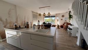 una cucina con lavello e un soggiorno di La Villa Pangea un havre de paix unique avec vue sur la rivière et la nature a Gignac