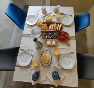 a table with breakfast food on a table with blue chairs at Como EM Casa in Alburitel