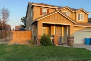 una casa amarilla con una valla en un patio en Spacious House in Marysville 9 minutes to Hard Rock Casino Wheatlan, en Marysville