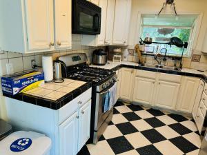a kitchen with a stove and a checkered floor at Cozy House Nested Around Trees E in San Jose