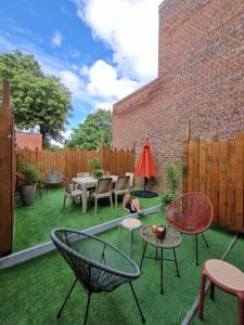 a backyard with chairs and tables on the grass at Le Vauban Cambrai in Cambrai