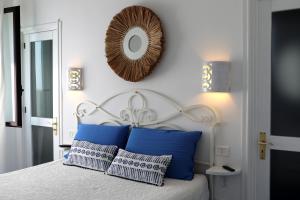 a bedroom with a bed with blue pillows and a mirror at Kalè in Giovinazzo