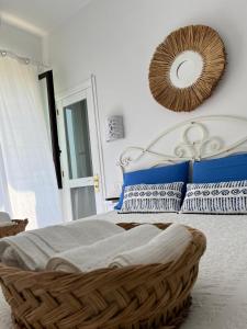 a bed with blue and white pillows and a mirror at Kalè in Giovinazzo