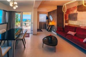 a living room with a red couch and a glass table at Taormina Seaview - Luxury Apartment in Taormina in Taormina +14 photos