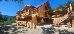 a log cabin with a bench in front of it at Cabana dintre Salcami in Durau