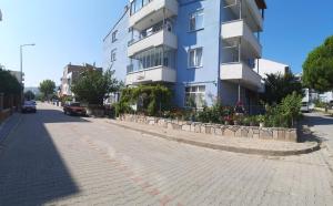 un edificio blu su una strada di ciottoli di Hilal Pansiyon a Çanakkale