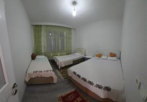 una camera da letto con due letti e una finestra di Hilal Pansiyon a Çanakkale
