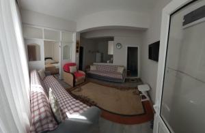 un soggiorno con un divano e un letto di Hilal Pansiyon a Çanakkale