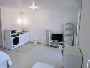 a white living room with a washer and dryer at Plume, Studio Non Fumeurs & Parking Gratuit à Sartrouville in Sartrouville