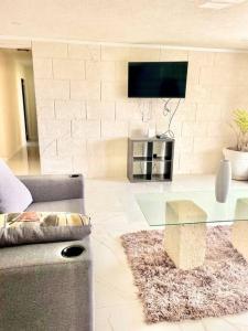 sala de estar con mesa de cristal y TV en Barbados Exotic luxury living, en Christ Church