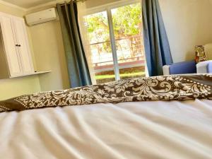 1 cama con edredón marrón y blanco y ventana en Barbados Exotic luxury living, en Christ Church